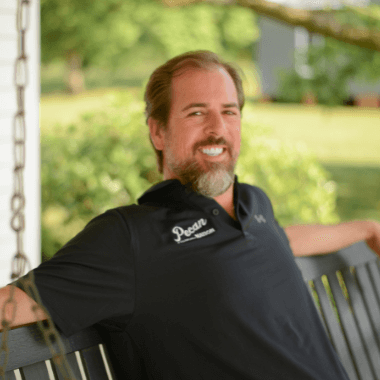 Kent in a dark grey shirt sitting on the bench